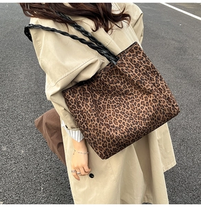 Chic leopard print tote bag with black woven handles paired with a beige trench coat