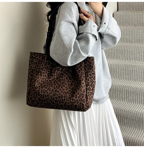 Detail of leopard print tote bag with thick woven rope handles shown on shoulder