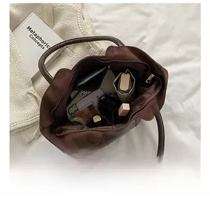 Macro view showing high capacity interior of deep brown vintage tote bag with zipper pocket