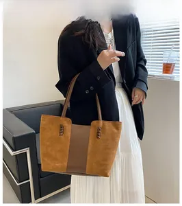 Close-up of brown patchwork tote bag with suede texture and woven side details