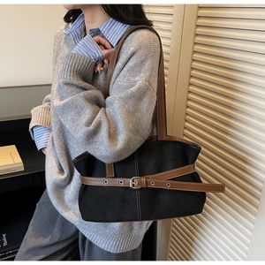 Detail of vintage tote bag with black suede texture and brown leather strap accents