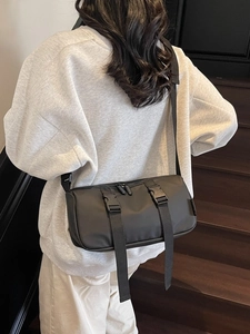 Casual black nylon crossbody barrel bag with adjustable strap and buckle detail