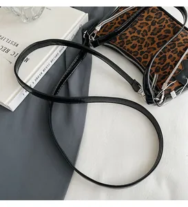Close-up of leopard print shoulder bag with black leather trim and silver zipper detail