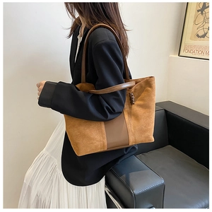 Brown suede tote bag with leather straps styled with a black blazer for office look