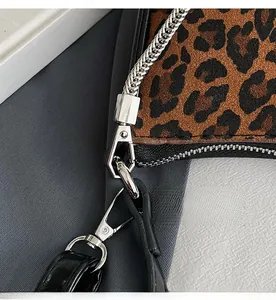 Detail of silver alloy swivel hook and chain strap on leopard print crescent bag