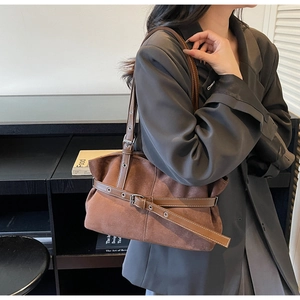 Detail of dark brown suede tote bag with retro leather belt buckle and silver hardware