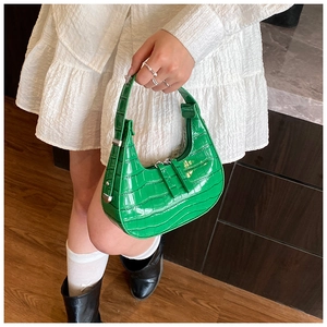 Macro view of bright green crocodile pattern leather crescent hobo bag for women