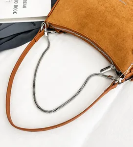 Detail view of brown suede underarm bag with silver chain and leather shoulder strap