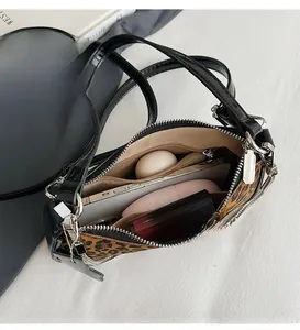 Interior view showing the spacious storage capacity for makeup and phone in leopard bag