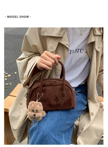 Detail der dunkelbraunen Wildleder-Kissentasche mit Plüschbär-Anhänger von Model