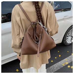 Outdoor view of large brown pleated leather tote bag showing rich texture and capacity