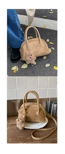 Detail der Vintage-Wildleder-Boston-Tasche in Camel mit süßem Plüschhund-Anhänger