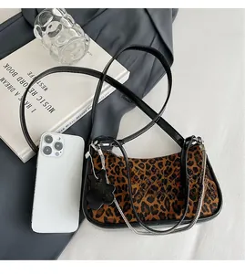 Detailed size comparison of leopard print hobo bag with phone and daily essentials