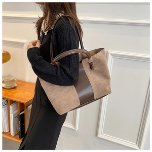 Detail of vintage tote bag showing brown smooth leather and light suede stitching