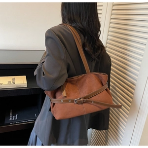 Brown frosted tote bag showing side buckle and zipper details on a shoulder carry