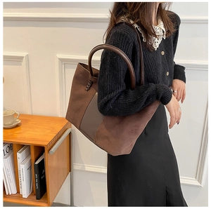 Detail of dark brown tote bag showing mixed suede and smooth leather with woven accents