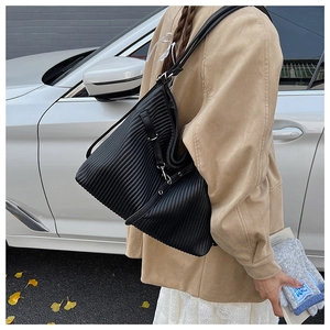 Close-up of black pleated texture detail on a large capacity minimalist shoulder tote bag