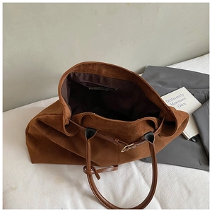 Macro shot of brown suede tote bag interior featuring fabric lining and zipper pocket
