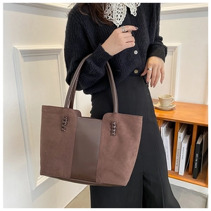 Detail of vintage brown tote bag featuring material splicing and woven texture