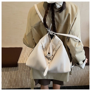 Detail showing white pleated texture and silver buckle of the large shoulder bag
