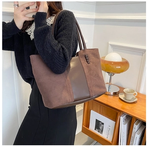 Detail of vintage brown tote bag with contrast textures and woven side details on a shelf