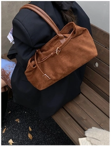 Close-up of brown suede tote bag featuring metallic buckle and long straps for women