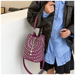 Detail der lila Punk-Beuteltasche mit silbernen Nieten und Kette an einem Model