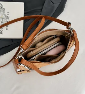Detailed interior of the brown crossbody bag showing spacious compartments and zipper pocket
