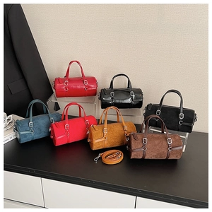 Macro detail of cylinder Boston bags in various colors and leather textures with silver hardware