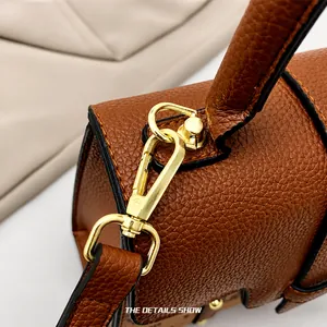 Close-up of premium gold-plated lobster clasp and lychee grain leather on brown handbag