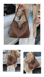 Detail of dark brown pleated tote bag featuring vertical textures and silver metal buckles