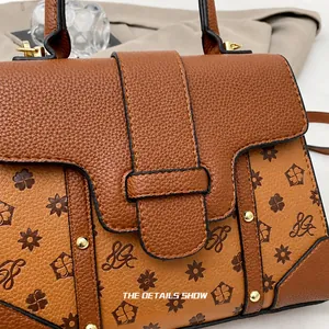 Close-up of caramel leather handbag featuring embossed patterns and gold rivet details