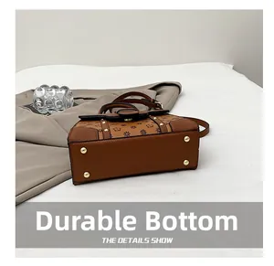 Detail of durable handbag base with gold-tone protective studs and vintage monogram pattern