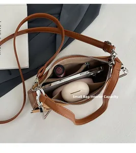 Internal view of brown leather bag showing space for phone, earbuds and lipstick