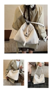 Detailed view of cream-colored accordion pleated tote bag with silver metal buckles