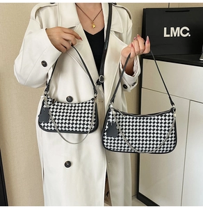 Macro shot of checkered crescent shoulder bags in two sizes with silver chain and bear charm