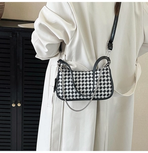 Close-up of checkerboard shoulder bag featuring silver chain and black leather straps