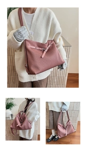 Detail of dusty pink tote bag showing vertical pleated texture and adjustable strap