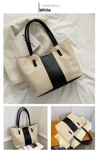 Detail of canvas tote bag with black leather trim and woven cross pattern