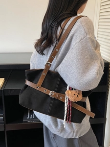 Black suede tote bag with brown leather straps and cute plush bear charm on shoulder