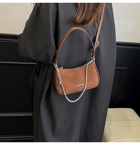 Detail of a brown crescent shoulder bag with vintage silver chain and leather strap