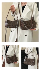 Detail view of the leopard print hobo bag with a decorative silver chain and flower charm