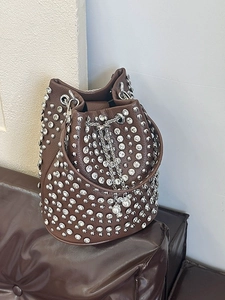 Braune Punk-Beuteltasche mit Strass und Perlen-Kordelzug auf einem Ledersofa