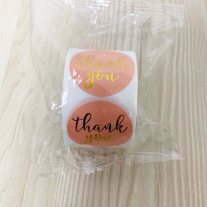 Detail of pink and gold foil Thank You stickers on roll in clear packaging