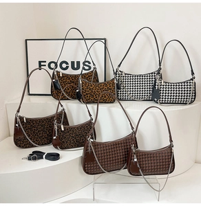 Detail of leopard print, checkered, and woven crescent shoulder bags with metal chains