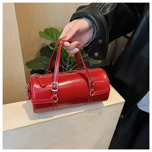 Detail of red cylindrical handbag in glossy patent leather with silver metal hardware