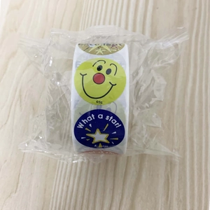Detail of roll-packed reward stickers with smile and star patterns in clear packaging