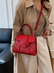 Elegant red leather handbag with floral embossing and adjustable shoulder strap for women