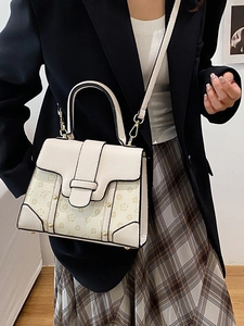 Beige faux leather handbag with brown floral patterns and adjustable shoulder strap