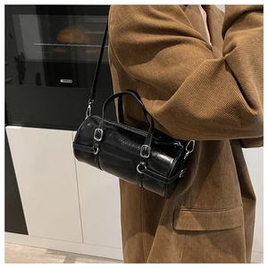 Side view of black cylinder barrel bag with silver hardware and glossy PU finish